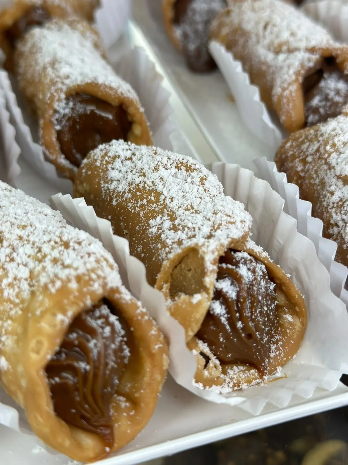 Cannoli recheados e polvilhados com açúcar